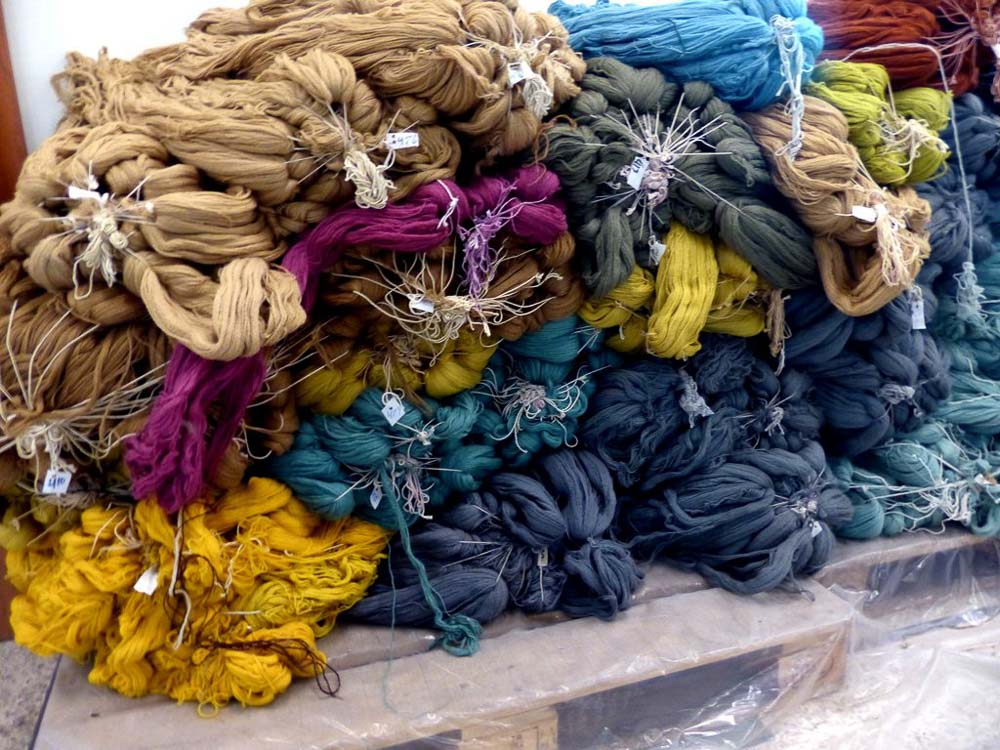 Dyed wool stacked up in the Bunyaad warehouse, ready for rug knotting.